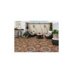 Baldosa 44x44 rojo geométrico Porcelanite, instalada en un piso de terraza con muebles de exterior y plantas