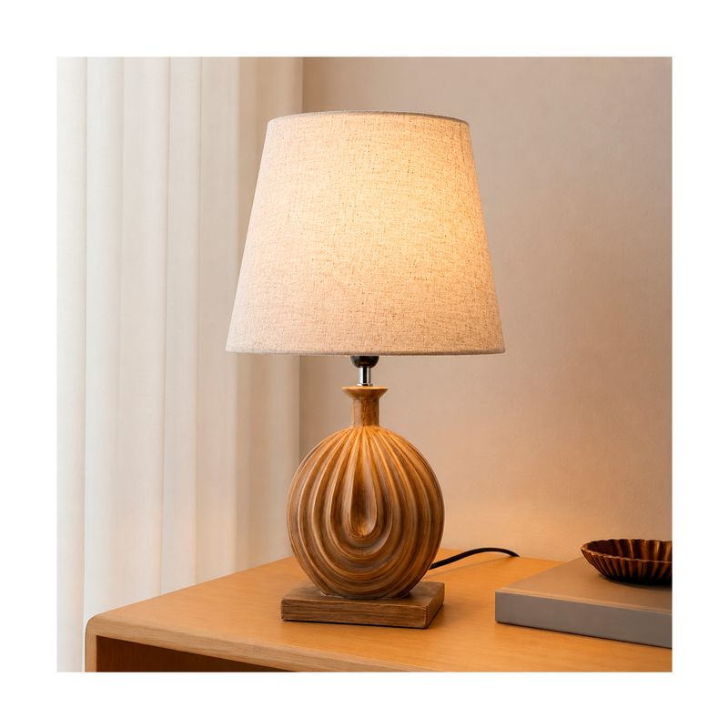 Pantalla para lámpara de mesa Lumara II 35 cm beige/café Concepts, encendida sobre una mesa de madera junto a un libro