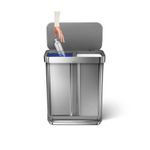 Basurero 2 compartimentos rectangular 58 L acero inoxidable Simplehuman, abierto con una mano depositando una botella