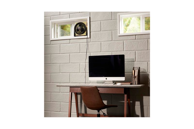 Abanico de mesa Turbo Force 3 velocidades negro Honeywell, colocado sobre el marco de una ventana en oficina moderna