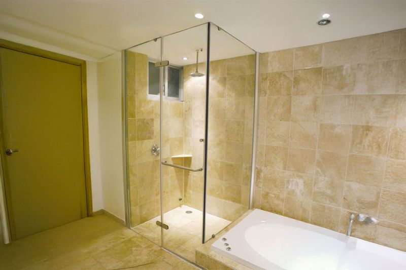 Cabina para baño rectangular 80x150x200 Sinsa, instalada en baño con paredes de piedra y bañera blanca al lado