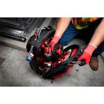Mochila Packout 48 bolsillos Milwaukee, abierta mostrando un taladro rojo y herramientas en su interior