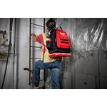 Mochila Packout 48 bolsillos Milwaukee, vista trasera de un trabajador usándola con una caja acoplada en la base