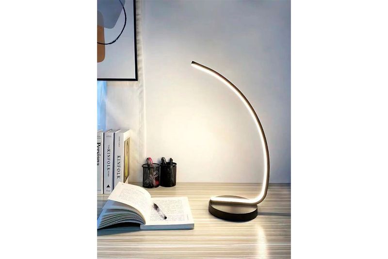 Luminaria de mesa LED 8 W 4000 K negra Equinox, encendida sobre un escritorio con libros y portalápices