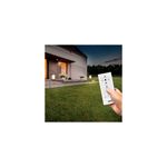 Miniposte LED farol SQ solar controlable CCT RGB bronce OneSync Feit Electric, mano sosteniendo el control remoto blanco
