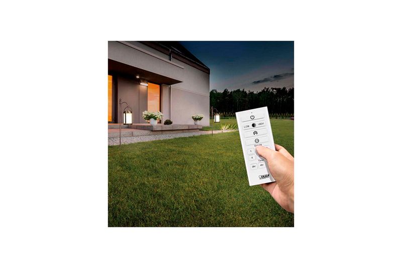 Miniposte LED farol SQ solar controlable CCT RGB bronce OneSync Feit Electric, mano sosteniendo el control remoto blanco