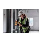 Kit nivel láser inalámbrico de líneas cruzadas 20V DeWALT, siendo utilizado por una operaria en una obra en construcción