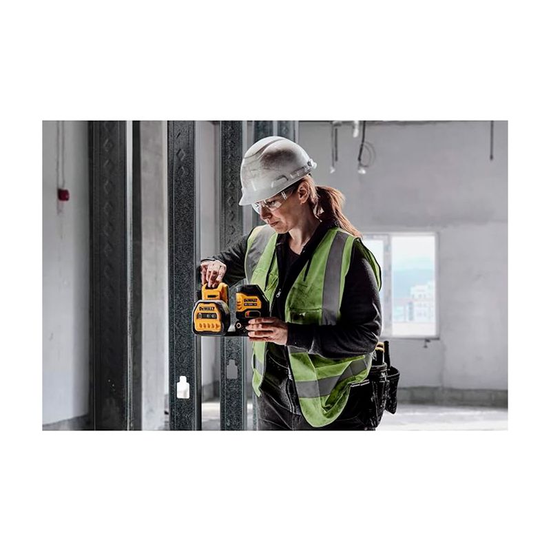 Kit nivel láser inalámbrico de líneas cruzadas 20V DeWALT, siendo utilizado por una operaria en una obra en construcción