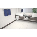 Baldosa 54 x 54 Campina blanco mármol brillante Serra Azul, instalada en el piso de un baño con mueble marrón