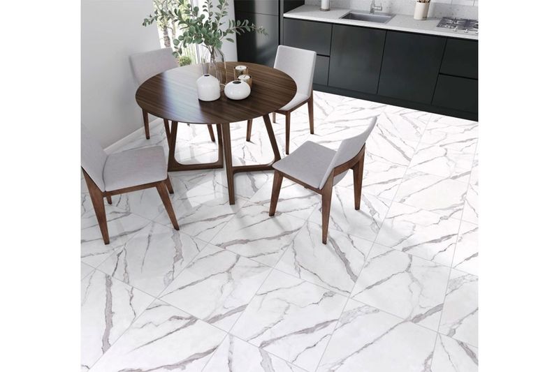 Baldosa 54 x 54 Córdova blanco mármol satinado Serra Azul, instalada en piso de comedor con mesa y sillas