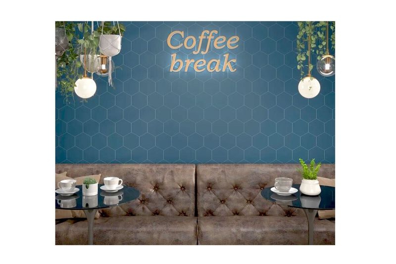 Azulejo 15 x 17 Opal hexagonal tormenta mate Estudio Cerámico, instalado en pared azul con letrero Coffee break y muebles