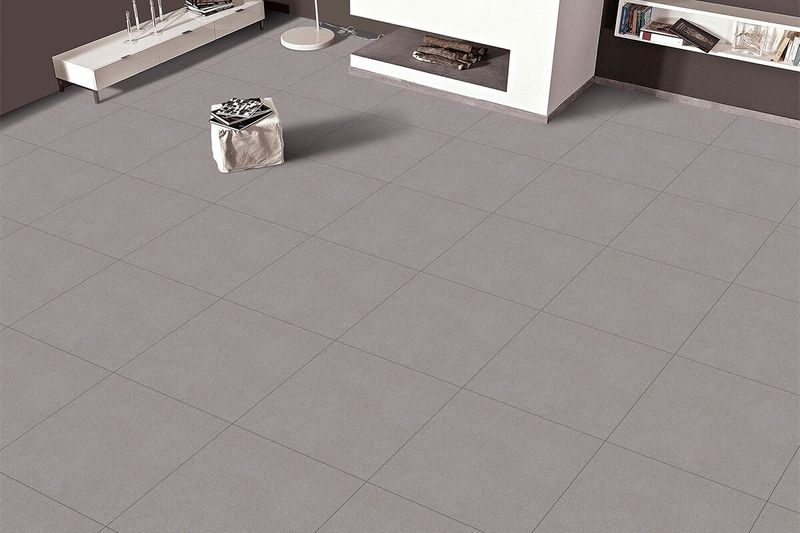 Porcelanato 60x60 Rock Grey mate Casciano, colocado en el piso de una sala moderna con muebles blancos