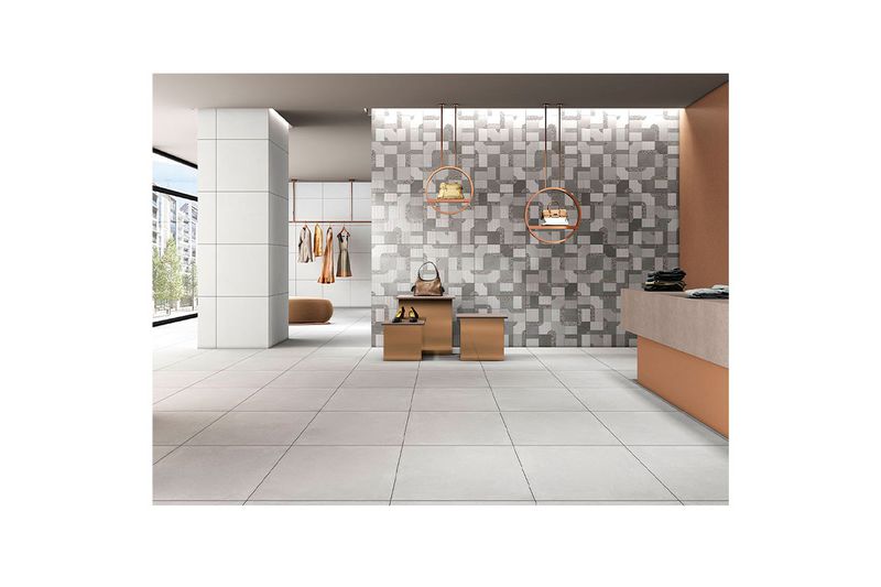 Porcelanato 60 x 60 Poetry Grigio mate rect Sunhearrt, aplicado en piso de una tienda con muebles y ropa al fondo