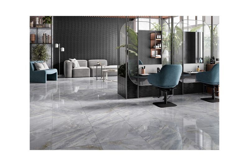 Baldosa 55x55 Bluette azul/gris mármol Porcelanite, instalada en piso de interior con acabado brillante y vetas grises