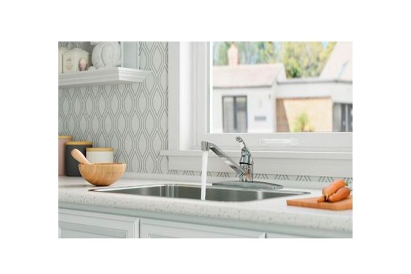 Llave para pantry 1 manija cuello bajo Pfister Series, instalada en fregadero con chorro de agua activo y zanahorias al lado