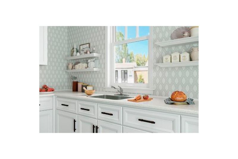 Llave para pantry 1 manija cuello bajo Pfister Series, instalada en fregadero de cocina blanca con accesorios decorativos