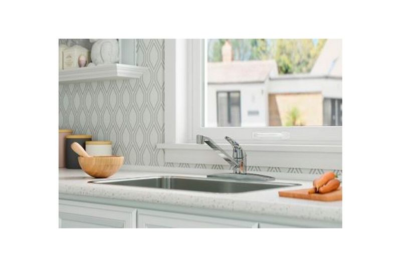 Llave para pantry 1 manija cuello bajo Pfister Series, instalada en fregadero de cocina frente a una ventana