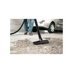 Aspiradora doméstica WD1 120V Kärcher 3.17 gal 1200W, boquilla de succión aspirando suciedad en el suelo junto a un auto