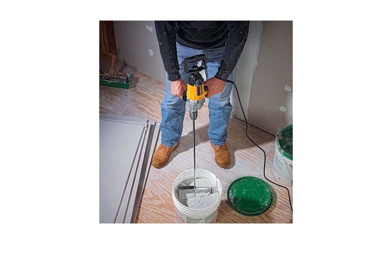Taladro tipo espada 5/8 pulgadas 710 W 0-550 RPM 9 A 120 V DeWALT, siendo usado por una persona para mezclar pasta en un cubo