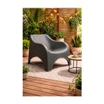 Silla individual verde Nuvola Koopman, ambientada en terraza de madera con plantas y mesa lateral pequeña