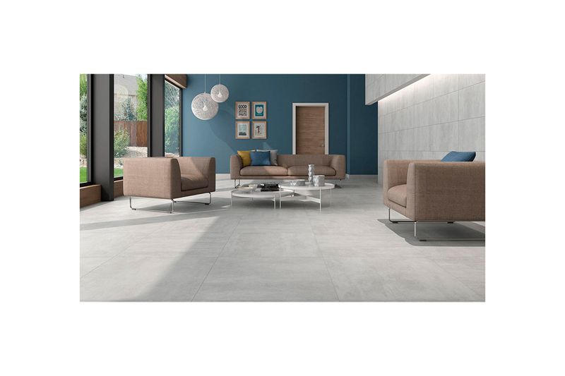Porcelanato 60x60 Provenza R10 antislip gris rect Pamesa, instalado en piso de sala con muebles modernos y pared azul