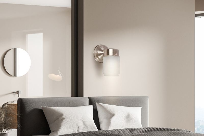Luminaria de pared clásico Ikelite níquel E27 1 luz 60 W, instalada en pared beige sobre el respaldo de una cama