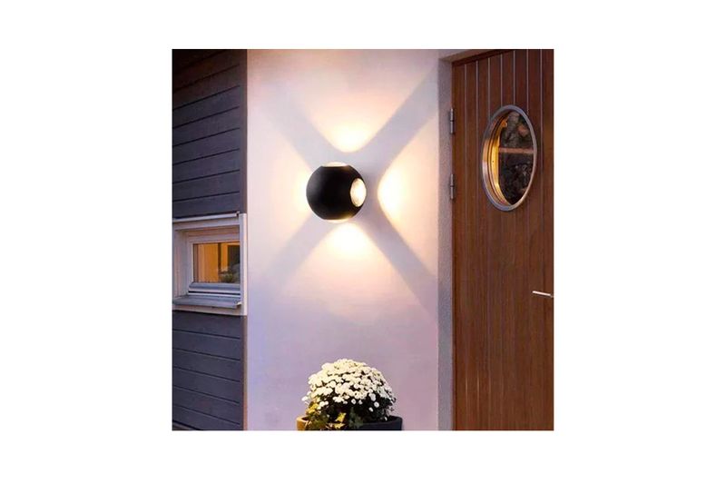 Luminaria de pared al exterior LED Veritate I 4 W 3000 K IP54 IK06 negro Tecnolite, instalada en pared iluminando hacia