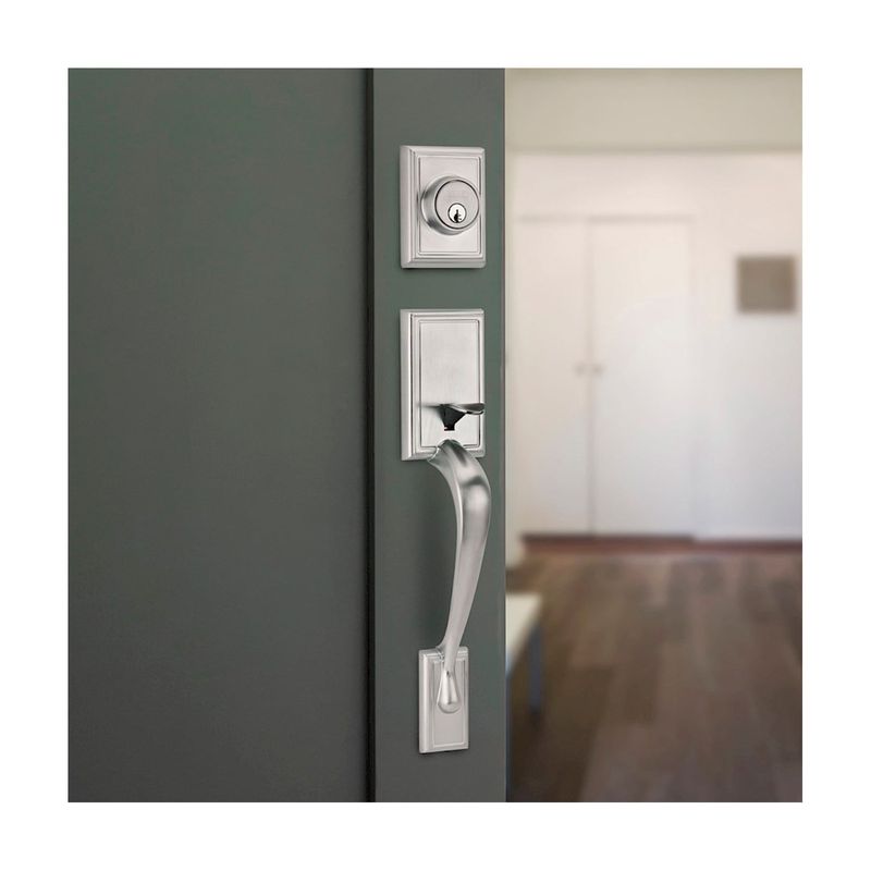 Cerradura pichel llave/llave Liberty satín níquel Kwikset, vista lateral instalada en puerta gris con cerradura superior